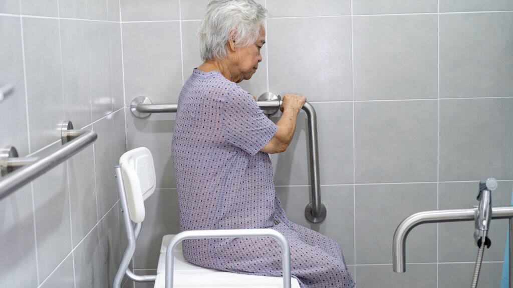 an old woman sitting on a toilet