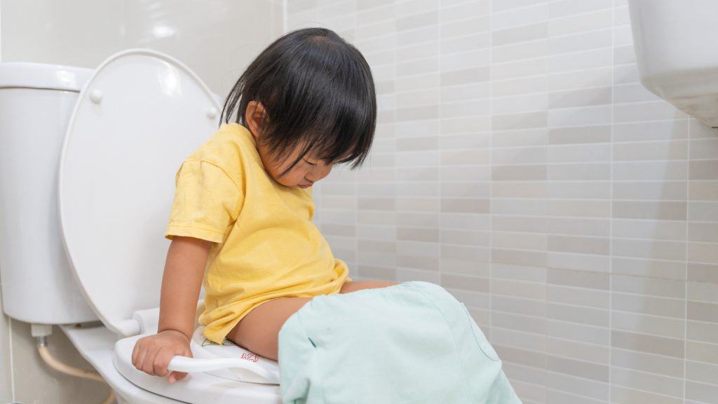 a child sitting on a toilet