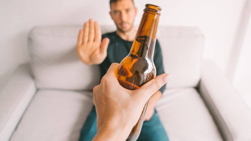 a hand holding a beer bottle